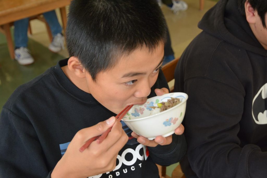 写真：秋田由利牛を使った給食を食べる児童2
