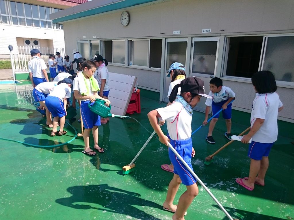 写真：プール清掃を行う生徒の様子