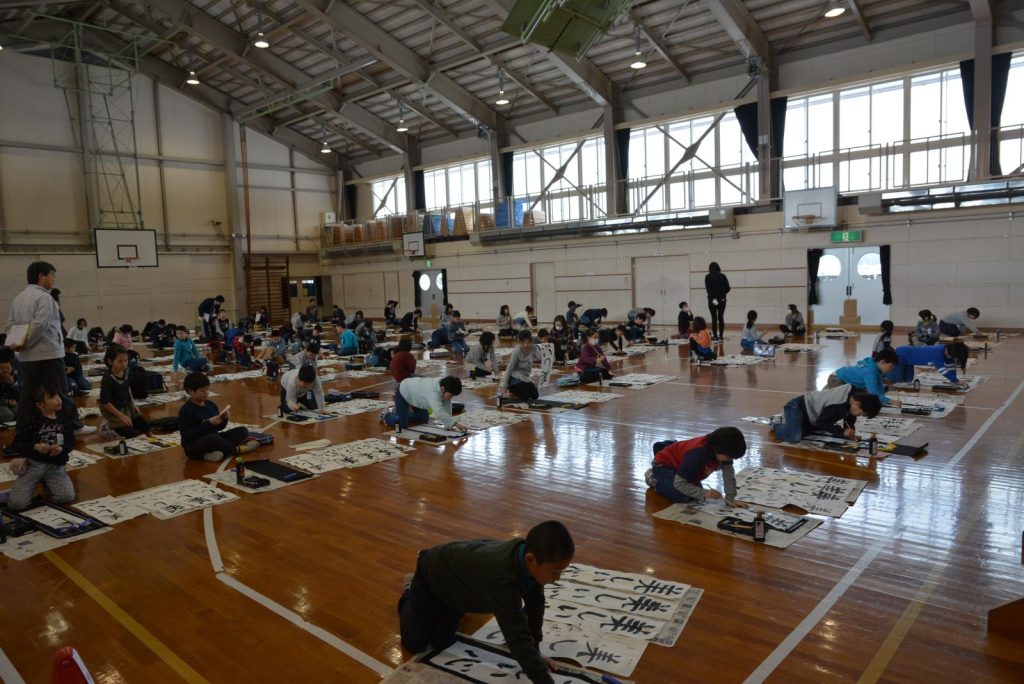 写真：校内書き初め大会での3年生から6年生の様子