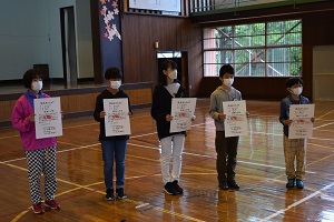 写真：小学校陸上競技大会の賞状を持つ生徒たち
